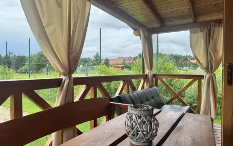Idealne miejsce, gdzie na Mazury z dziećmi. Drewniany taras z widokiem na zieleń i boisko.