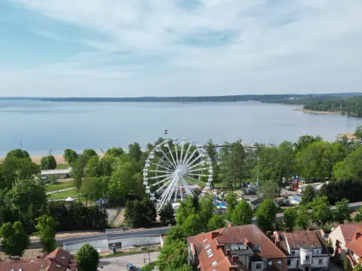 Widok na jezioro i park rozrywki z diabelskim młynem w Giżycku.