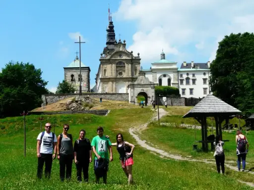 Grupa turystów na tle klasztoru na Świętym Krzyżu, miejscu pełnym łysa góra legend.