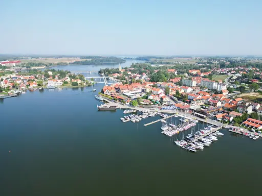Malownicze miasteczko z mariną pełną żaglówek i domów z czerwonymi dachami. Idealne miejsce na letni wypoczynek, jakbyśmy byli na plaży w Mikołajkach.