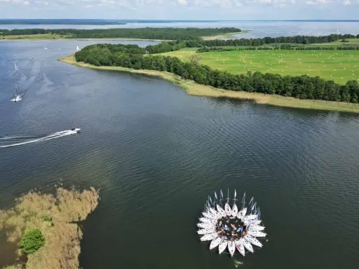 Kwiat z żaglówek na jeziorze, otoczony zielonymi polami i lasami. Piękny widok na Warmia i Mazury.