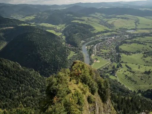 Widok z góry na Trzy Korony. Rzeka Dunajec meandruje przez zieloną dolinę, w której leży malownicza miejscowość.