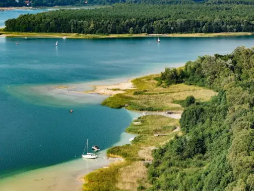 Turkusowa woda, piaszczyste plaże i zielone lasy tworzą malowniczy krajobraz. To **najczystsze jezioro w Polsce**, idealne do żeglowania i wypoczynku.