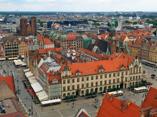 Widok z góry na kolorowy rynek z kamienicami, ratuszem i kościołem. To chyba najładniejszy rynek w Polsce, tętniący życiem.