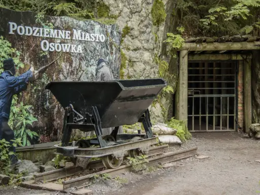 Wejście do Podziemnego Miasta Osówka, z wagonikiem i manekinem górnika. To jedno z wielu podziemnych miast w Polsce.