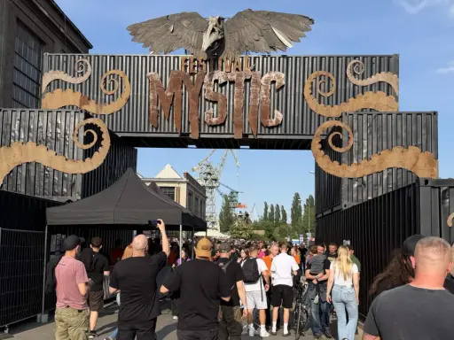 Tłum ludzi wchodzi przez bramę festiwalową "Mystic". To jedno z wielu wydarzeń kulturalnych, takich jak festiwale filmowe w Polsce.