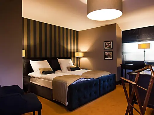 Przytulny pokój hotelowy z dużym łóżkiem, idealny na romantyczny wypad. Co można robić w Lublinie z dziewczyną? Tu na pewno odpoczniecie.