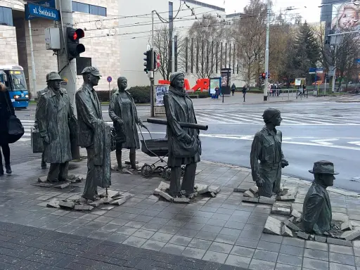Słynne pomniki w Polsce: grupa postaci wychodząca z chodnika, symbolizująca przejście przez czas.