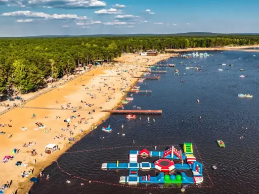 Słoneczny dzień na zalewach świętokrzyskich. Tłumy plażowiczów, wodne atrakcje i mnóstwo łódek na tafli wody.