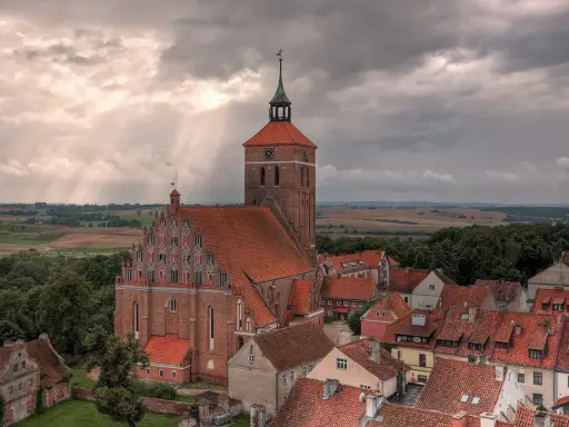 Gotycka ceglana architektura i malowniczy krajobraz Mazur, świadectwo bogatej historii regionu.