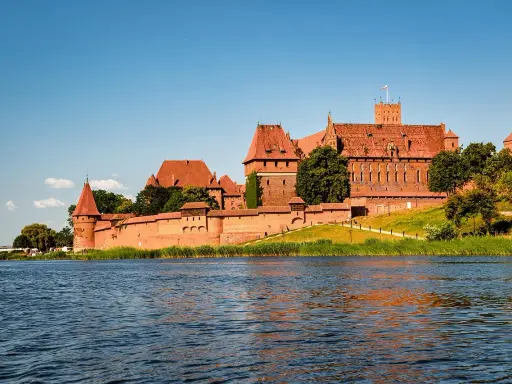 Zamek w Malborku, często uznawany za najlepsze muzeum w Polsce, majestatycznie wznosi się nad rzeką Nogat.