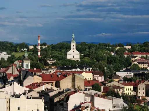 Widok na miasto z kościołem i wieżą, otoczone zielenią. To najstarsze miasto na Śląsku, pełne historii.
