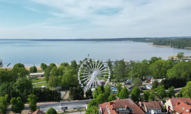 Widok na jezioro i park rozrywki z diabelskim młynem w Giżycku.