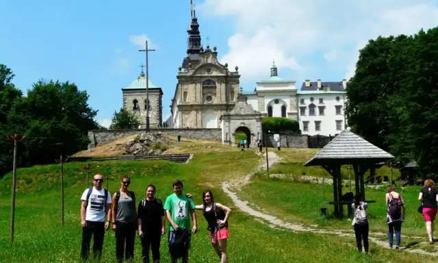 Grupa turystów na tle klasztoru na Świętym Krzyżu, miejscu pełnym łysa góra legend.