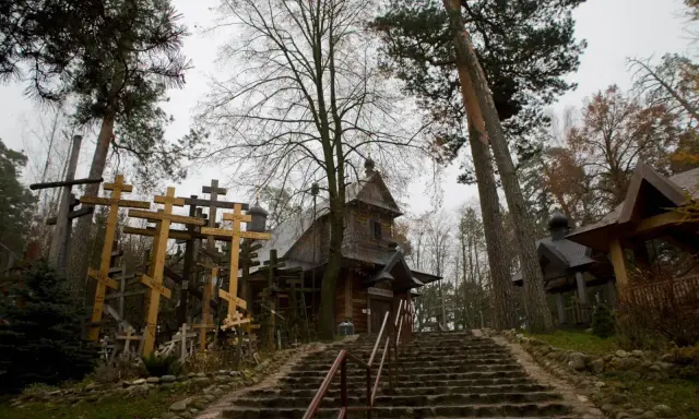 Kamienne schody prowadzą do drewnianej cerkwi otoczonej lasem i licznymi krzyżami. To miejsce, gdzie pielgrzymi szukają ukojenia, jak grabarka uzdrowienia.
