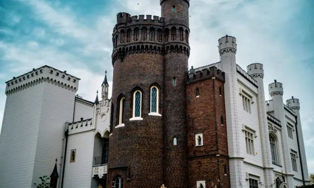 Zamek w Kórniku, jedna z najpiękniejszych atrakcji okolic Poznania, z ceglaną wieżą i białymi skrzydłami.