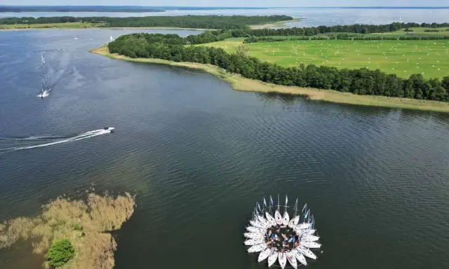Kwiat z żaglówek na jeziorze, otoczony zielonymi polami i lasami. Piękny widok na Warmia i Mazury.