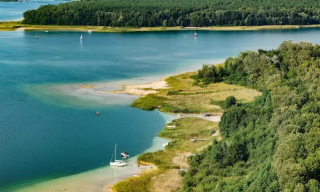 Turkusowa woda, piaszczyste plaże i zielone lasy tworzą malowniczy krajobraz. To **najczystsze jezioro w Polsce**, idealne do żeglowania i wypoczynku.