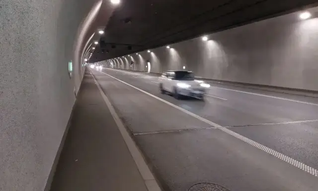 Biały samochód mknie przez oświetlony tunel w Zakopanem.