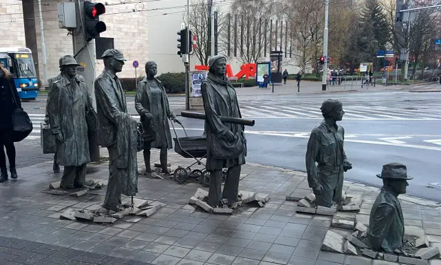 Słynne pomniki w Polsce: grupa postaci wychodząca z chodnika, symbolizująca przejście przez czas.