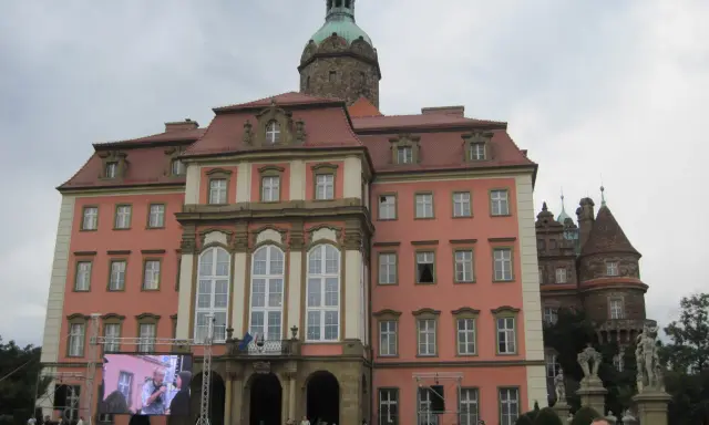 Zamek Książ z wieżą i ekranem LED przed fasadą, na którym wyświetlany jest obraz.
