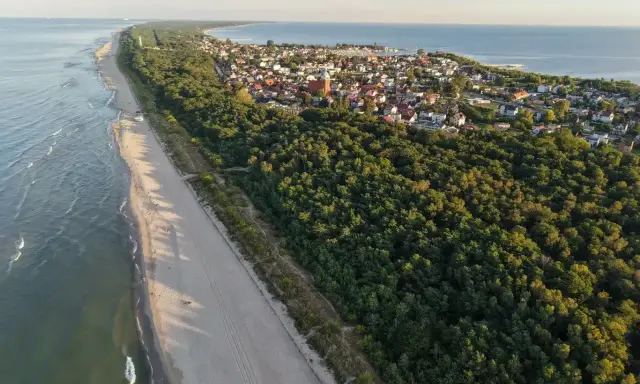 Piękna plaża i las, idealne miejsce, gdzie na majówkę. Widok z lotu ptaka na nadmorską miejscowość.