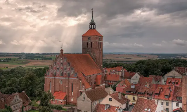 Gotycka ceglana architektura i malowniczy krajobraz Mazur, świadectwo bogatej historii regionu.