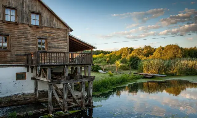 Drewniany młyn nad wodą, otoczony zielenią. Idealne miejsce na weekendowe wypady, szukając fajne miejsca niedaleko Warszawy na weekend.