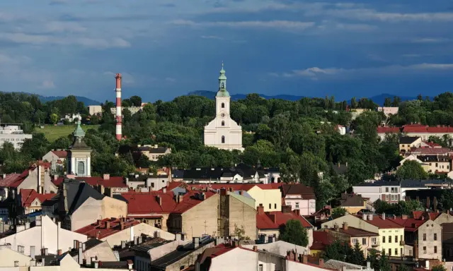 Widok na miasto z kościołem i wieżą, otoczone zielenią. To najstarsze miasto na Śląsku, pełne historii.