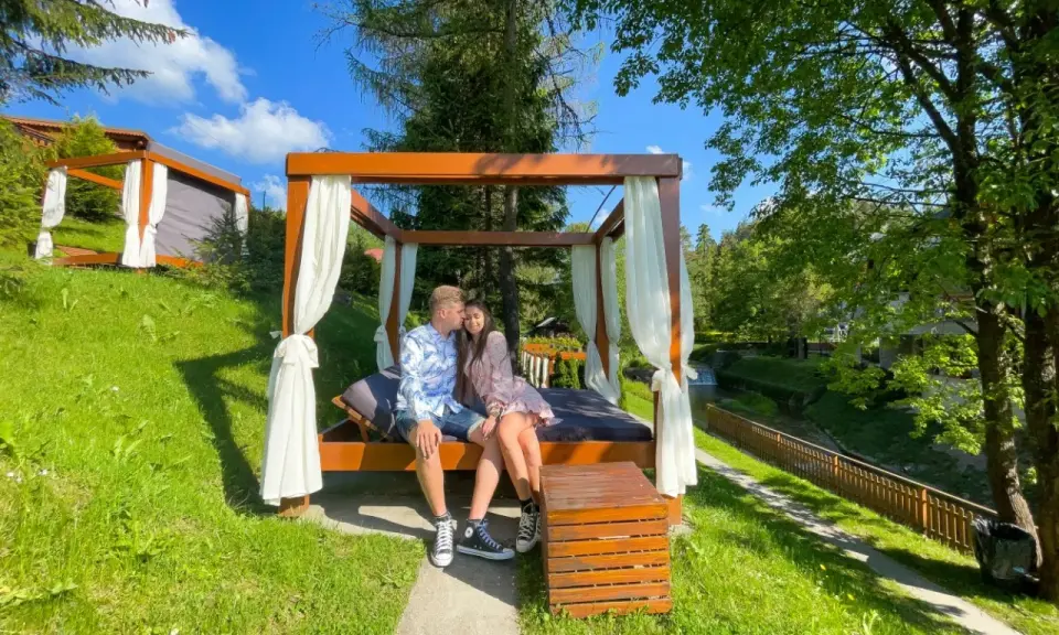 Para siedzi na łóżku pod baldachimem, idealne miejsce, gdzie na romantyczny weekend.