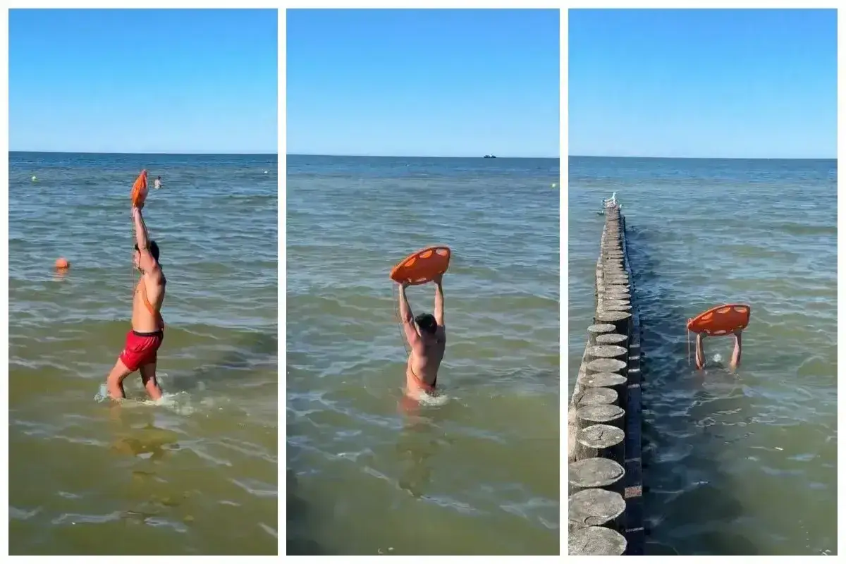 Ratownik z kołem ratunkowym przy falochronach nad morzem. Słońce, woda i bezpieczeństwo plażowiczów.