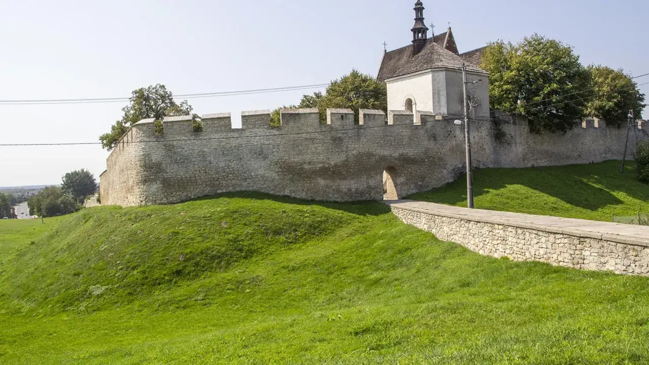 Kamienne mury obronne i kościół na wzgórzu w Szydłowie. Rynek w Szydłowie, otoczony historyczną zabudową, zachęca do spaceru.