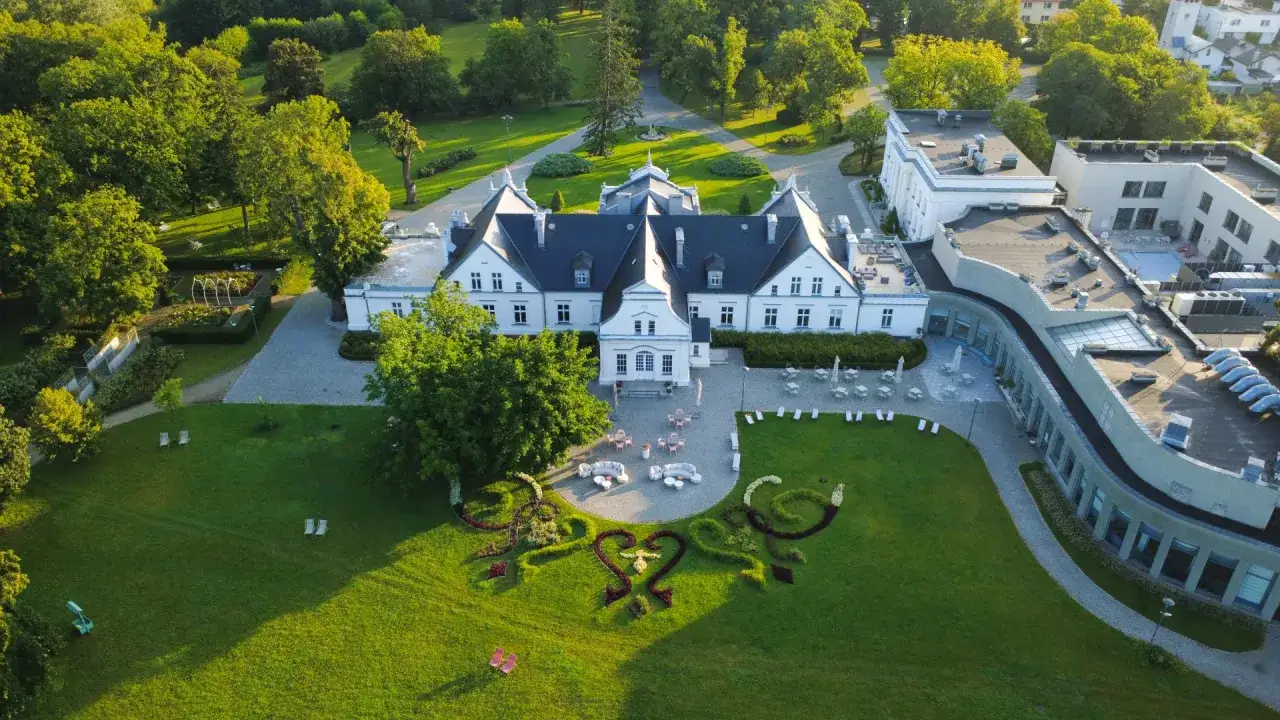Pałac otoczony parkiem, z kwiecistymi sercami na trawniku. Idealne romantyczne miejsca na Śląsku na wyjątkowe chwile.