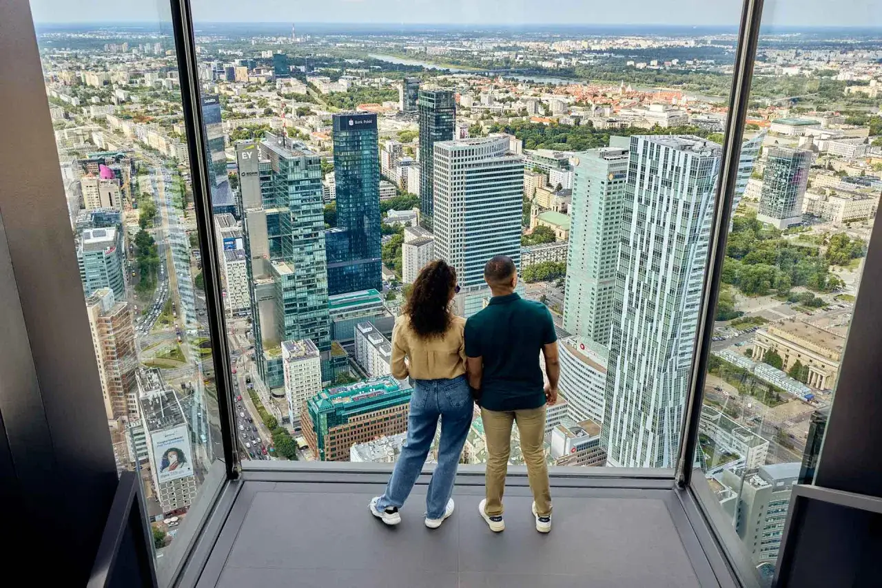 Para zwiedzająca taras widokowy Varso Tower podziwia panoramę Warszawy.