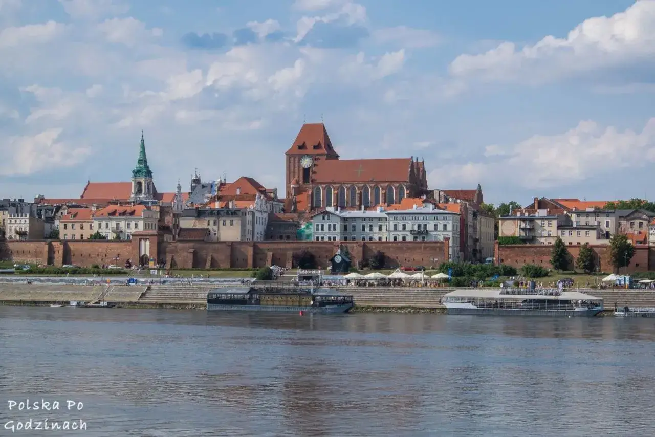 Widok na zabytkowe Stare Miasto w Toruniu, wpisane na listę obiekty UNESCO w Polsce. Rzeka Wisła i statki wycieczkowe.
