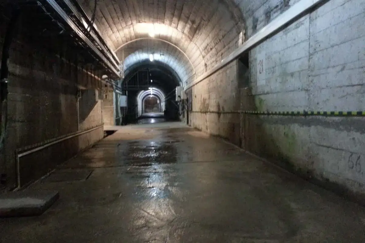 Wnętrze tunelu podczas zwiedzania elektrowni Solina. Mokra posadzka odbija światło lamp.