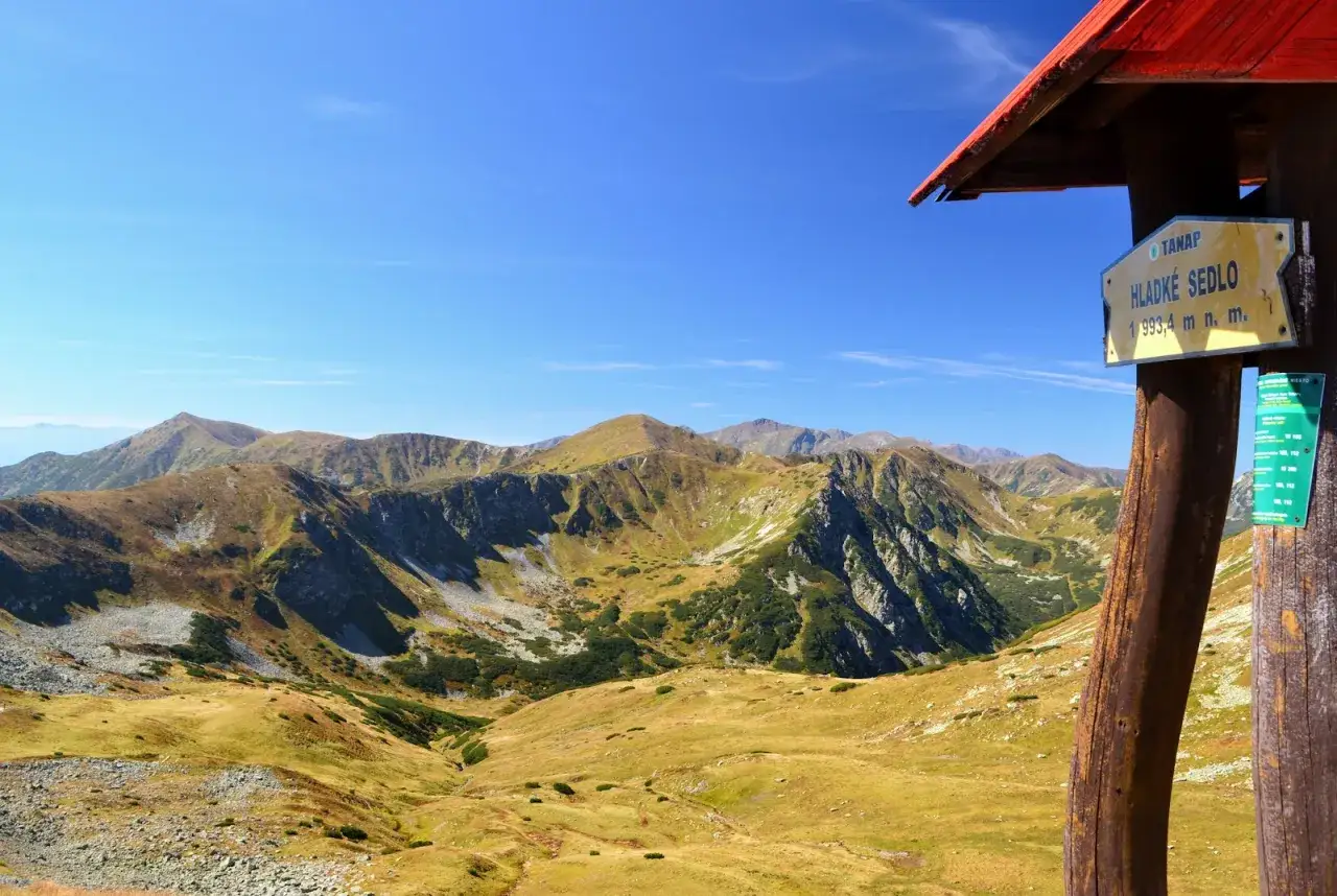 Widok na malownicze Tatry Wysokie z żółtym drogowskazem