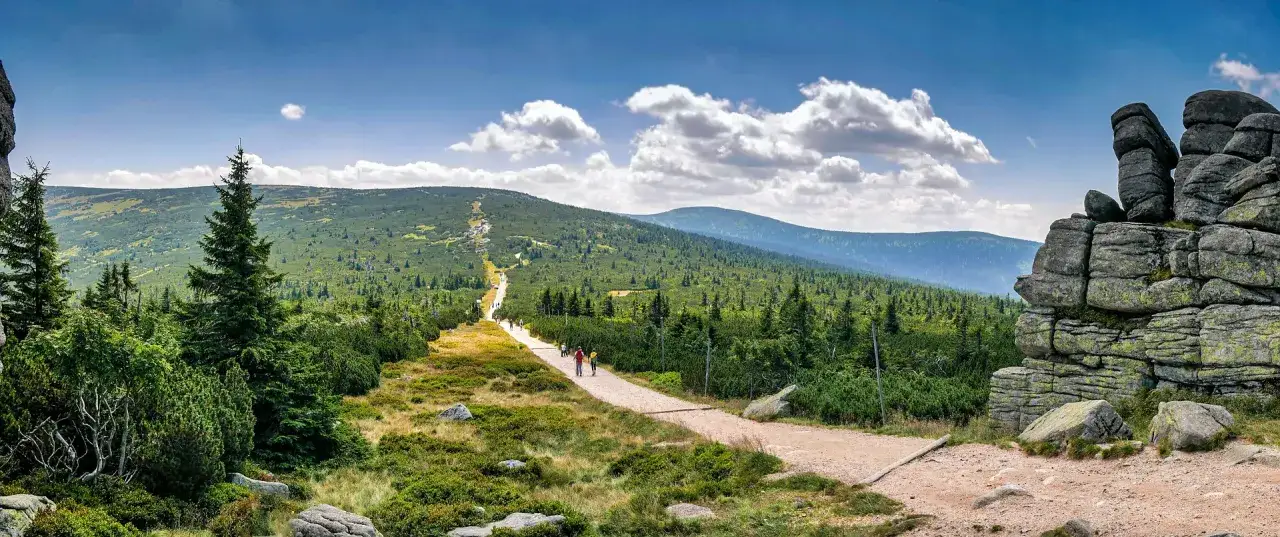 Szklarska Poręba jakie góry? Widok na Karkonosze z kamienistym szlakiem, sosnami i skalnymi formacjami.