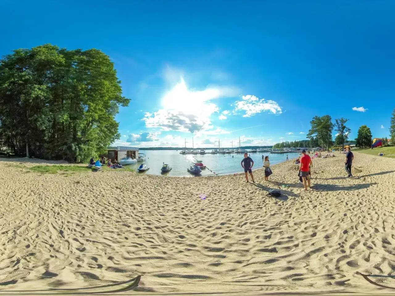 Słoneczne plaże na Mazurach zachęcają do wypoczynku. Piasek, woda i łodzie tworzą idealny krajobraz.