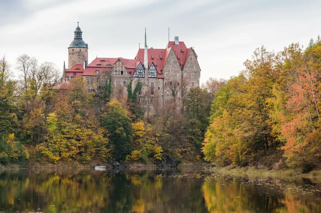 Zamek Książ w Wałbrzychu, otoczony jesiennym lasem, to jedno z tych ciekawe miejsca w polsce na jednodniowy wypad, które zachwyca o każdej porze roku.