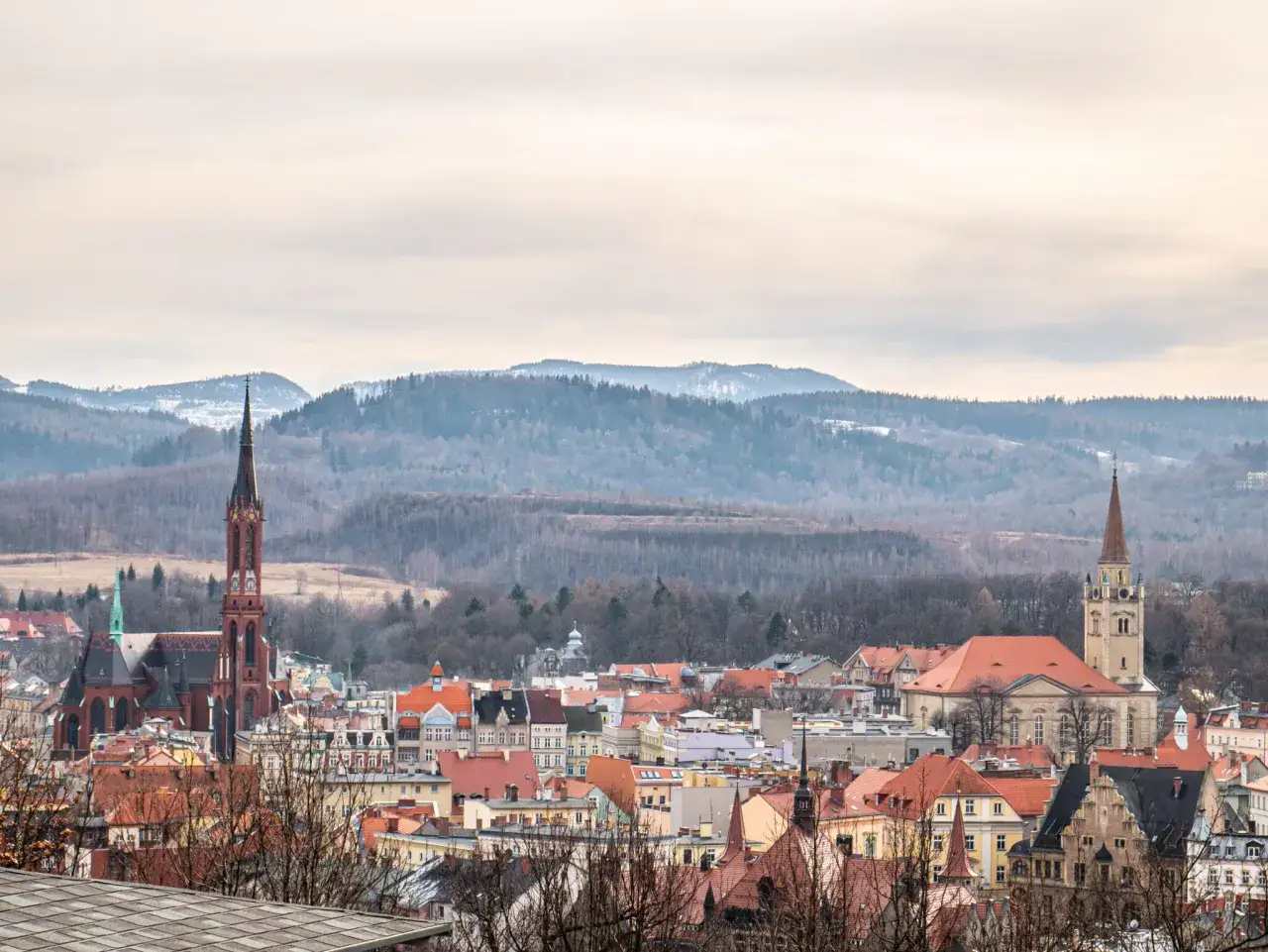 Panorama Wałbrzycha z górami w tle. Warto zobaczyć gotycki kościół i inne zabytkowe budowle.