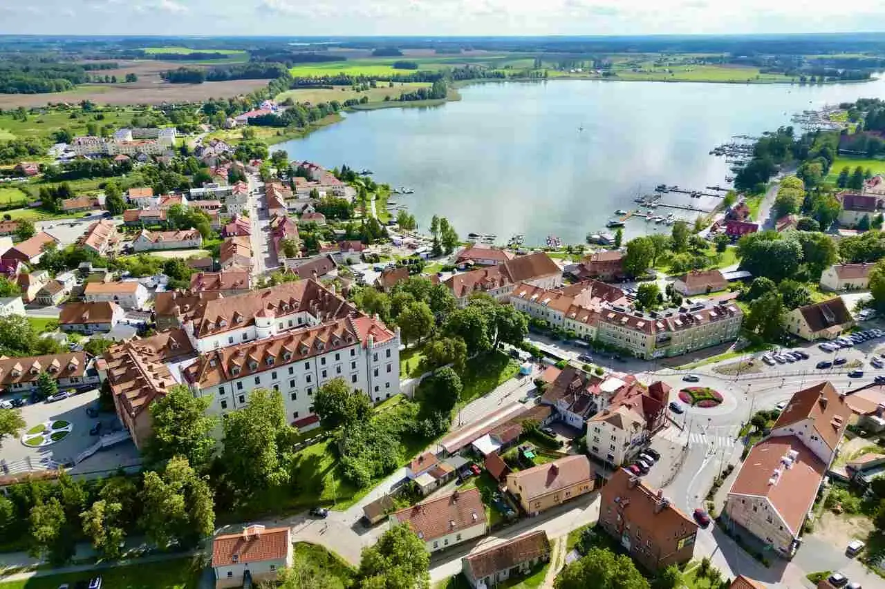 Widok na miasteczko nad jeziorem, gdzie zamek i kamienice opowiadają historię Mazur.